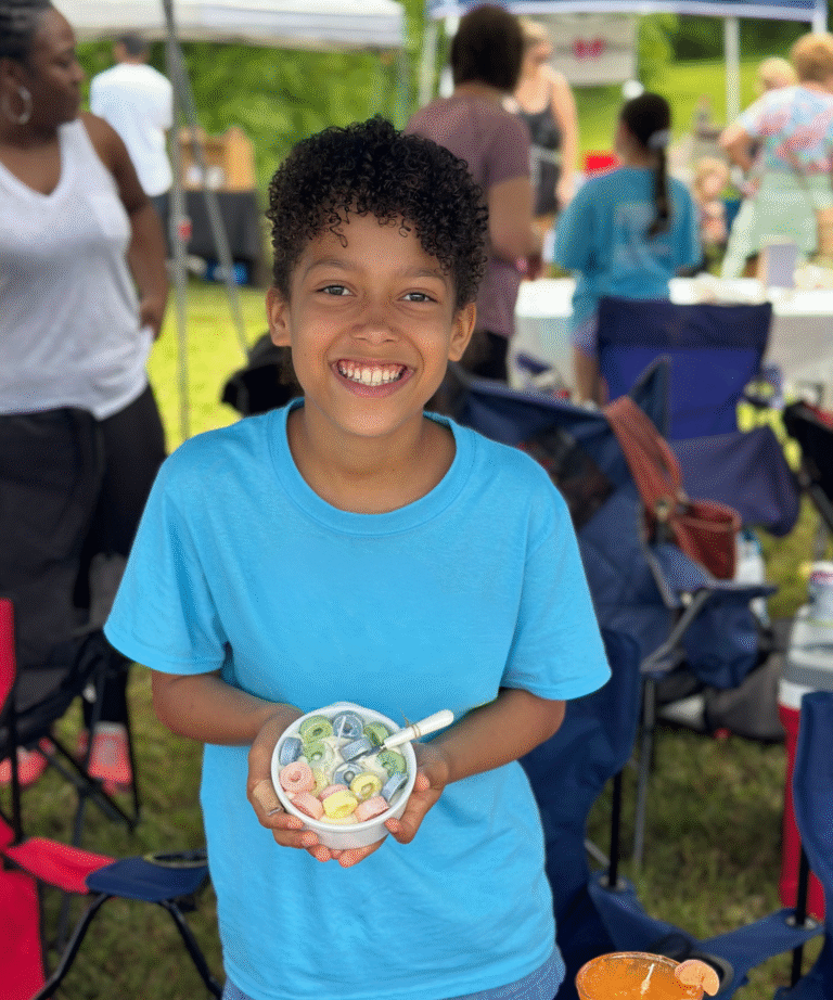 Young Entrepreneur holding a candle she made at a local market.